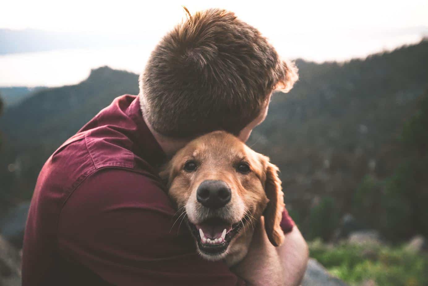 man hugging dog