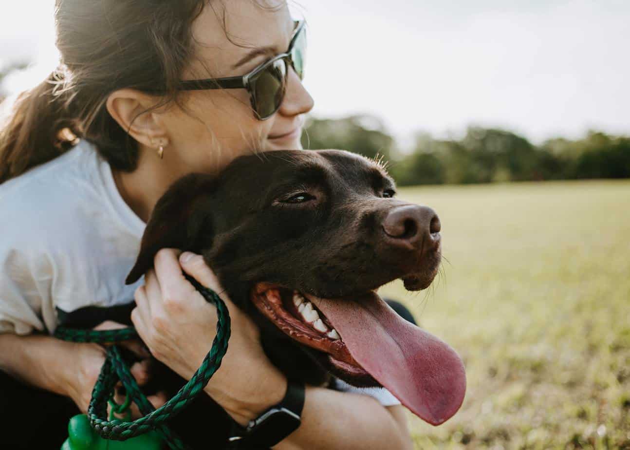 girl hugging a brown dog 